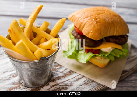 Burger and bucket with fries. Stock Photo