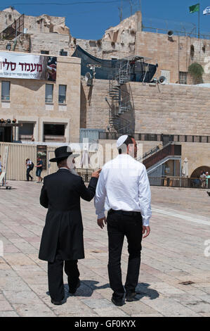 Jerusalem: Jews walking in front of the Western Wall, Wailing Wall or Kotel, a surviving remnant of the Temple Mount, the holiest place for Hebraism Stock Photo