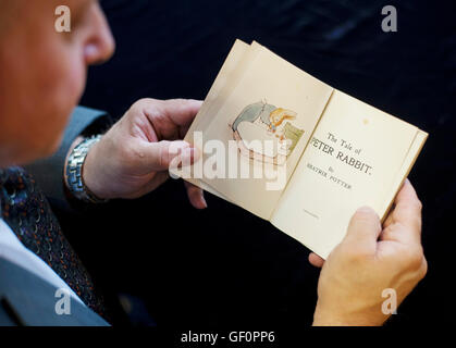A member of staff holds a first issue of The Tale of Peter Rabbit, estimated at &pound;25,000-35,000, which will be auctioned in the Beatrix Potter Books and Works on Paper sale on her 150th anniversary at Dreweatts &amp; Bloomsbury Auctions in London. Stock Photo