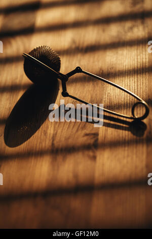 Tea strainer on wooden background. Selective focus. Stock Photo