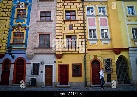 A man walks past tall, narrow houses with colourful facades lining a street near the centre of Wroclaw, Poland. Stock Photo