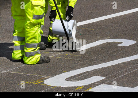 City Council maintenance roadworkers paint white lines on streets. Chapter 8 Traffic Management systems in place on major long-term road works and temporary traffic lights & signs on Preston arterial road, B5253 Flensburg Way in Farington Moss, Lancashire, UK. Stock Photo