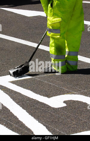 City Council maintenance roadworkers paint white lines on streets. Chapter 8 Traffic Management systems in place on major long-term road works and temporary traffic lights & signs on Preston arterial road, B5253 Flensburg Way in Farington Moss, Lancashire, UK. Stock Photo