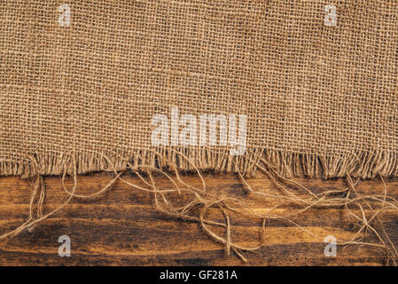 Burlap hessian sacking on wooden background, rustic backdrop Stock Photo