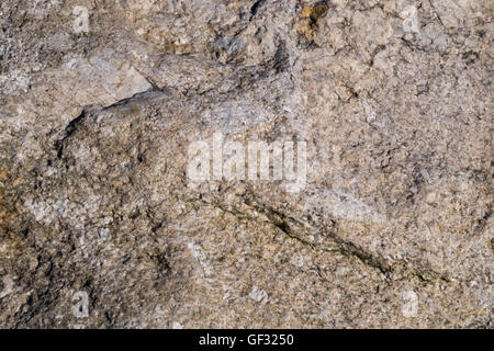 Fractured and weathered surface of a large granite rock. Stock Photo