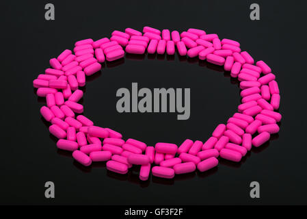 Migraine Pills pink capsules vitamins on black background Stock Photo