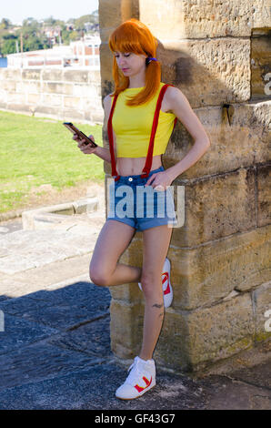 Sydney, Australia: 29th July 2016: Misty Pokemon Cosplay Photoshoot inspired by the release of the new game Pokemon Go. Pokemon Go is an app game that allows the player to catch Pokemon using virtual reality technology. Pictured is Becky, an Australian based cosplayer seen portraying the pokemon trainer Misty while enjoying the game around Cockatoo Island.   Credit:  mjmediabox / Alamy Live News Stock Photo