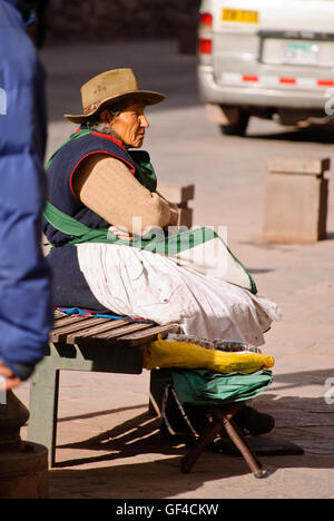 A Peruvian woman sitting on the street of Cuzco Stock Photo