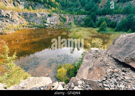 abandoned and flooded quarry, Czech Republic, teal and orange color tone. Beautiful landscape. Stock Photo