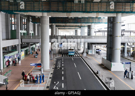 Japan, Kansai airport, KIX. Exterior. Bus drop off and pick up point, terminal 1. Main road, bus stops, pavement and ticket entrance to terminal. Stock Photo