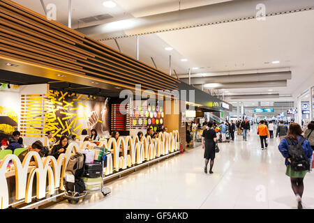 Japan, Osaka, Kansai airport, KIX. Interior of terminal one. Domestic check-in hall 2nd floor. McDonalds fast food restaurant and concourse with people. Stock Photo