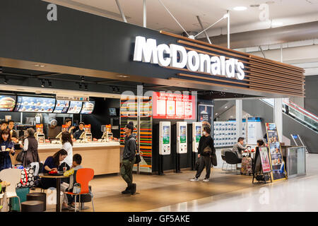 Japan, Osaka, Kansai airport, KIX. Interior of terminal one. Domestic check-in hall, 2nd floor. People at McDonalds fast food burger restaurant. Stock Photo