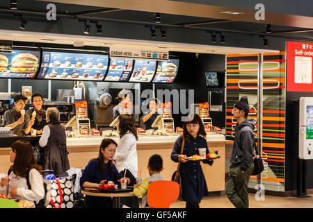 Japan, Osaka, Kansai airport, KIX. Interior of terminal one. Domestic check-in hall, 2nd floor. People at McDonalds fast food burger restaurant. Stock Photo