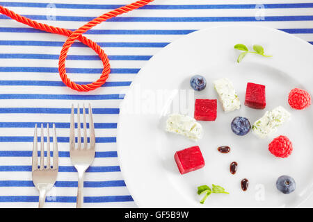 Appetizer made of beet, cottage cheese with fruits on sailing style decorated table. Stock Photo