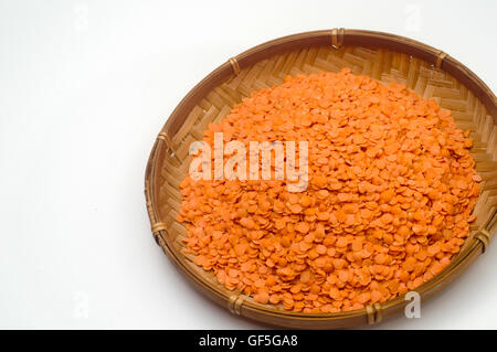 Organic Red lentils (Lens culinaris) in a straw dish on white background Stock Photo