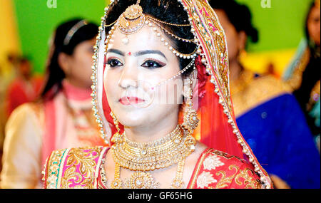 portrait of Indian bride wearing gold jewelry and red wedding costume Stock Photo