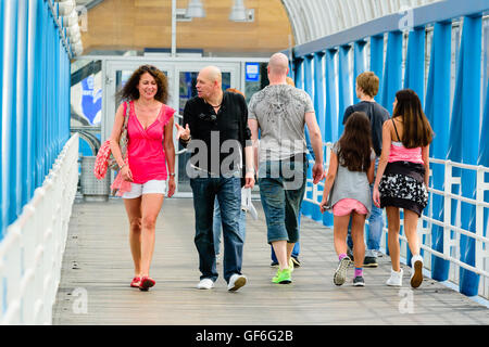 Goteborg, Sweden - July 25, 2016: Unknown people walking across an elevated public walkway. Attractive female and man walking to