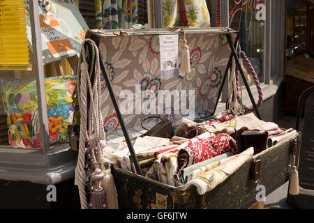 UK, England, Devon, Honiton, High Street, old trunk full of fabric remnants outside interior design shop Stock Photo