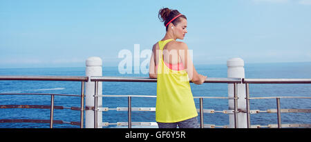 Look Good, Feel great!  Seen from behind young athlete in fitness outfit standing at the embankment Stock Photo