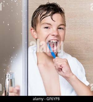 Teen boy brushing teeth Stock Photo