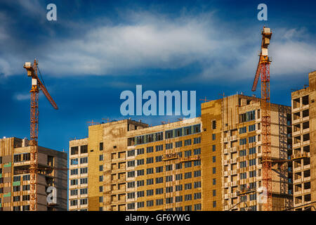 Crane and building construction site against blue sky Stock Photo