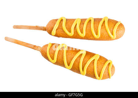 Two corn dogs isolated on white topped with mustard Stock Photo