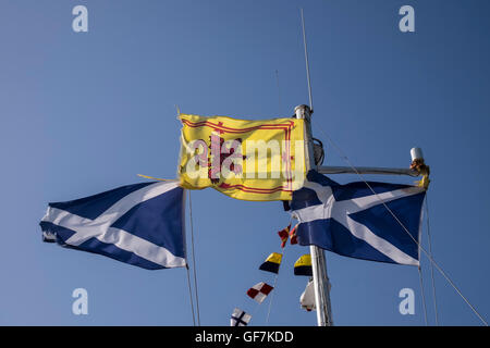 Royal Standard of Scotland with its red rampant lion on yellow background between two Scottish saltire flags with the cross of S Stock Photo