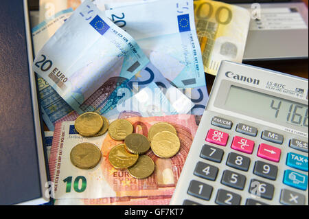 Various Euro notes and coins with a calculator, diary and laptop computer. Stock Photo