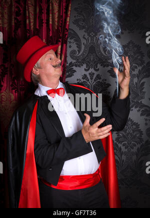 Funny magician making smoke out of his tuxedo sleeve Stock Photo