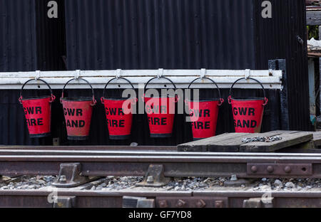 GWR Sand and Fire red buckets by the railway track at the Didcot Railway Centre in Oxfordshire Stock Photo