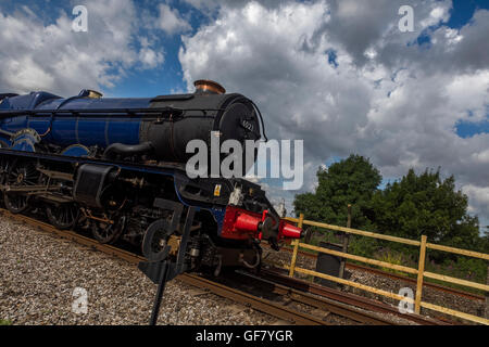 Restored King Edward II steam locomotive train on the tracks at an unusual dramatic angle with a dramatic cloudy sky Stock Photo