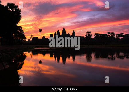 Angkor Wat temple at dramatic sunrise reflecting in water Stock Photo