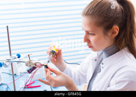 Tech tests electronic equipment in service centre Stock Photo