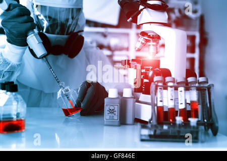 Laboratory examination of Ebola. Scientist takes blood pipette and microscope studies in biological samples. Stock Photo