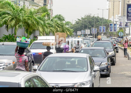 Street hawkers ply their wares in traffic, Victoria Island, Lagos, Nigeria, West Africa Stock Photo