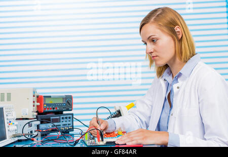 Tech tests electronic equipment in service centre Stock Photo