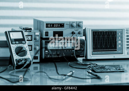 Development of electronic devices in the modern electronics laboratory, on a table, microprocessor oscilloscope and multimeter Stock Photo