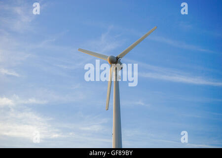 wind turbine against partly cloudy blue sky Stock Photo