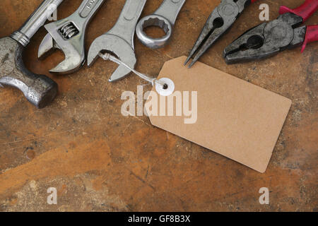 different tools on rustic wooden worktop with brown tag Stock Photo
