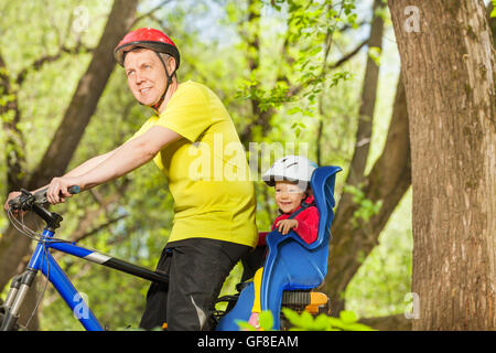 Happy father and his little daughter riding a bike Stock Photo