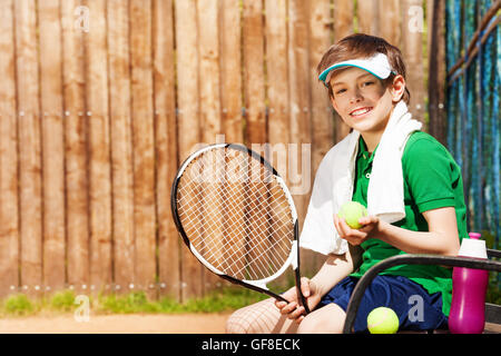 Young tennis player sitting on a bench after game Stock Photo