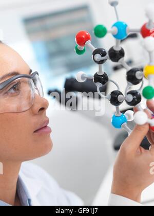 PROPERTY RELEASED. MODEL RELEASED. Scientist understanding a chemical formula by using a molecular model in a laboratory. Stock Photo