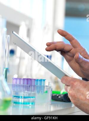 PROPERTY RELEASED. MODEL RELEASED. Scientist using a digital tablet to input data in a laboratory during an experiment. Stock Photo