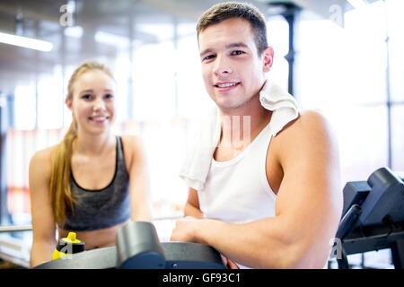 PROPERTY RELEASED. MODEL RELEASED. Young man and woman smiling in gym, portrait. Stock Photo