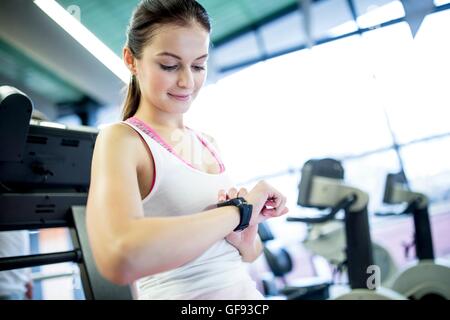 PROPERTY RELEASED. MODEL RELEASED. Woman using smart watch in gym. Stock Photo