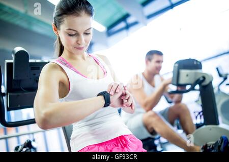 PROPERTY RELEASED. MODEL RELEASED. Woman using smart watch in gym. Stock Photo