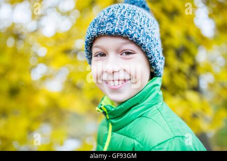 MODEL RELEASED. Boy wearing woolly hat and smiling, close-up, portrait. Stock Photo