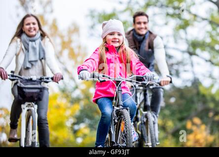 MODEL RELEASED. Family cycling together in autumn. Stock Photo