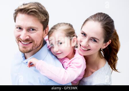 MODEL RELEASED. Portrait of dentist and dental assistant playing with girl, smiling. Stock Photo