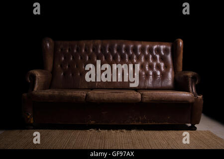 Vintage couch with a black background. Grunge style Stock Photo